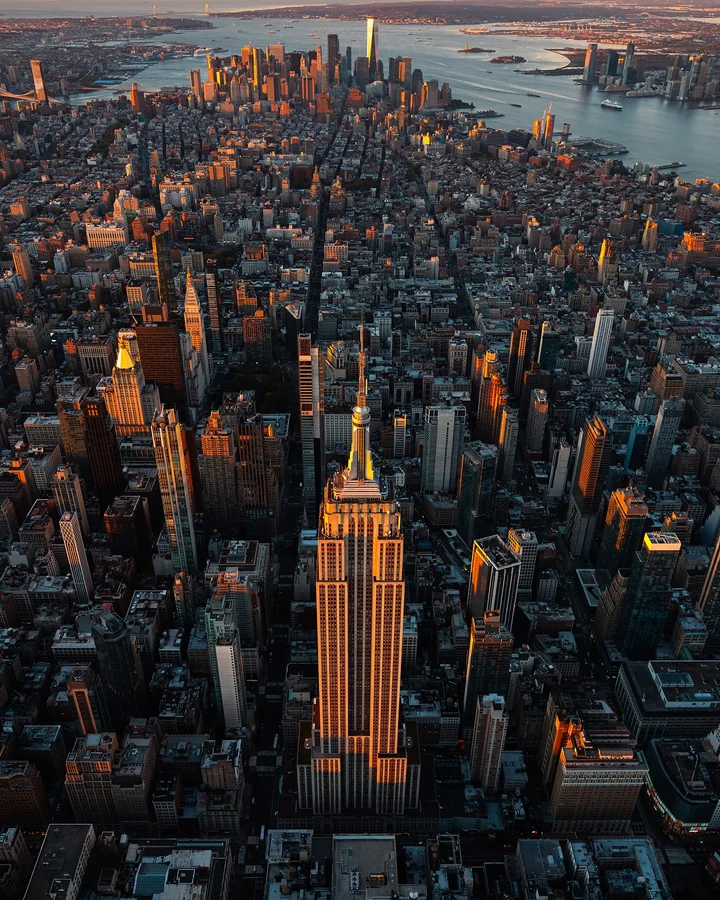 Empire State Building, downtown Manhattan and the harbor at golden hour